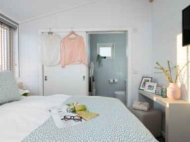 A bedroom with a bed and an adjoining bathroom at Mullion 2 Spa (Pet) Bude