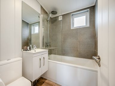 A bathroom with a shower and bath tub at Mullion 2 Spa (Pet) Bude
