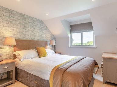 A bedroom with a bed and bedside tables at Summerleaze Garden Cottage 3 Spa Bude