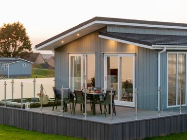 A building with a deck and dining setup at Mullion Spa in Bude