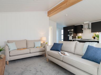 A living room with sofas and a lamp at Mullion Spa in Bude