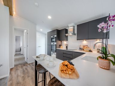 A kitchen with countertop, refrigerator, and cooking appliances at Mullion Spa (Pet) Bude