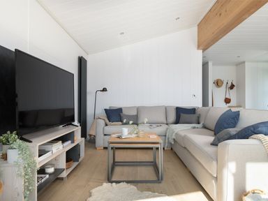 A living room with a sofa and television at Sennen 3 Spa Roof Terrace (Pet), Bude