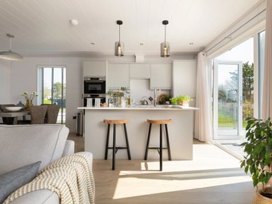 A kitchen with an island and dining area at Sennen 3 Spa Roof Terrace Bude