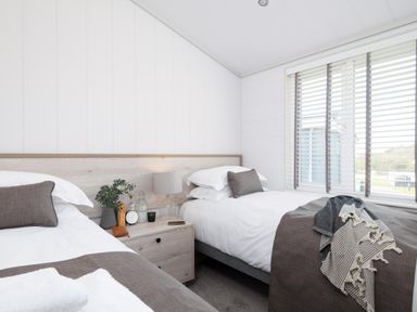 A bedroom with two beds and a nightstand at Sennen 3 Spa Roof Terrace, Bude