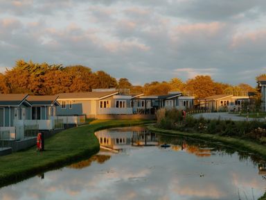 A view of holiday homes by a pond at Sennen 3 Spa Roof Terrace in Bude