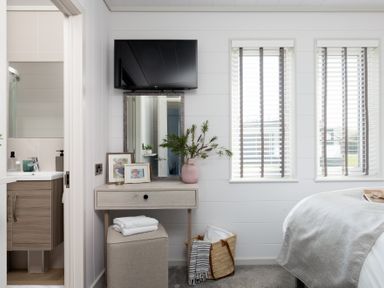 A bedroom with a nightstand and television at Sennen 3 Spa (Pet) in Bude