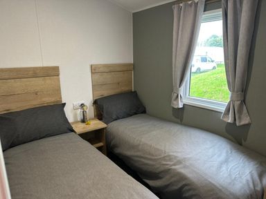 A bedroom with two single beds and a window at Willerby Ellerrton in Prestatyn