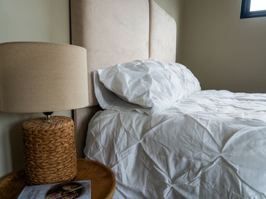 A bedroom with a bed, lamp, and side table at Cabin 2.0 in Dumfries