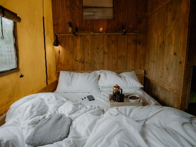 A bedroom with a bed and coffee set at Deluxe Safari Tent in Fair Oak