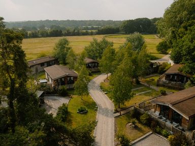 An outdoor area with cabins and a gravel path at Spitfire Lodge in Fair Oak