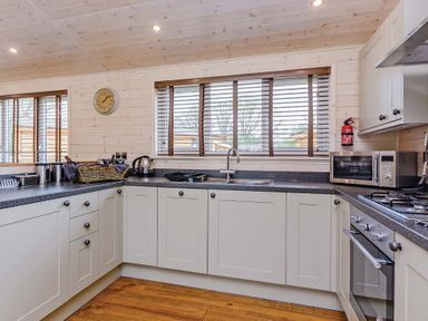 A kitchen with cabinets, sink, and appliances at Lancaster Lodge Fair Oak