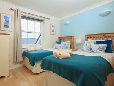 A bedroom with two beds and a chest of drawers at 8 Thurlestone Beach in Kingsbridge