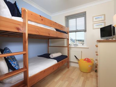 A bedroom with a bunk bed and a television at 8 Thurlestone Beach in Kingsbridge