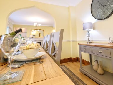 A dining room with a table set for a meal at Llwyn Derw in Talybont
