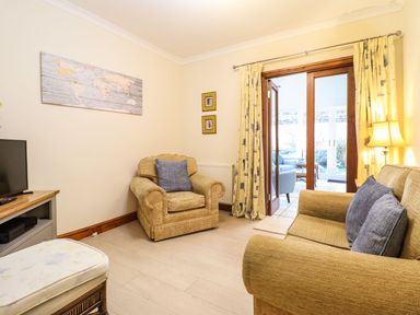 A living room with a sofa and armchair at Llwyn Derw in Talybont