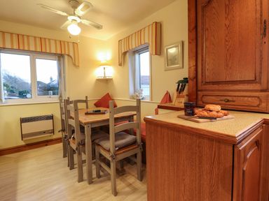 A kitchen with a table and chairs at Llwyn Derw in Talybont
