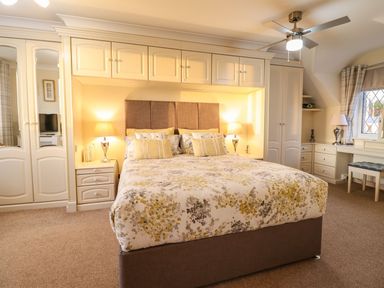 A bedroom with a bed and wardrobe at Llwyn Derw in Talybont