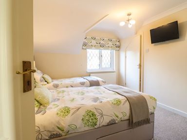 A bedroom with two beds and a television at Llwyn Derw in Talybont