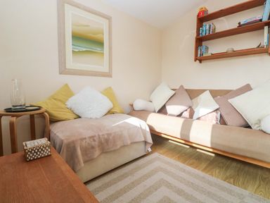A snug with a sofa and wall art at Chalet 225 in Tregolds near St Merryn