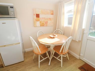 A dining room with a table and chairs at Chalet 225 Tregolds near St Merryn