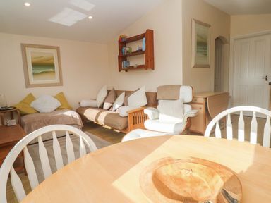 A living room with a sofa and table at Chalet 225 Tregolds near St Merryn