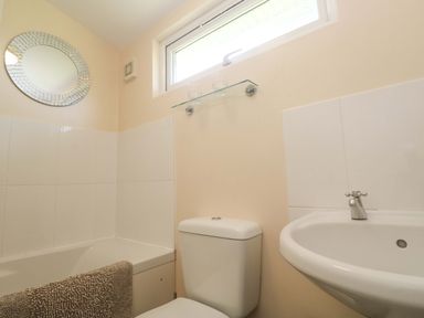 A bathroom with a bathtub sink and toilet at Chalet 225 Tregolds near St Merryn