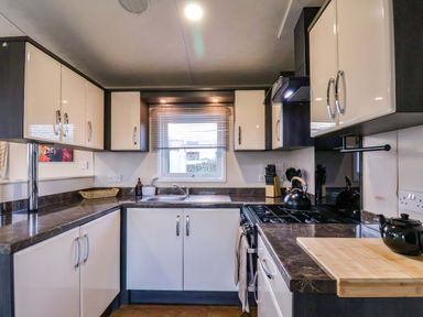 A kitchen with cabinets and a sink at Rosefinch Cabin in Scarborough
