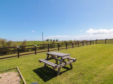 A picnic table on grass at Rosefinch Cabin Staintondale near Scarborough