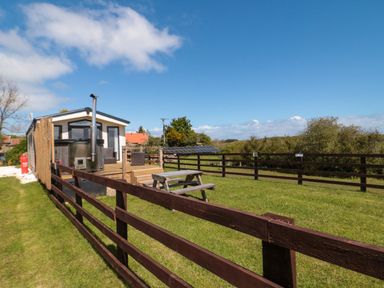 A cabin with a deck and picnic table at Rosefinch Cabin Staintondale near Scarborough