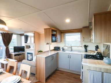 A kitchen with appliances and a dining table at Swift Cabin in Scarborough