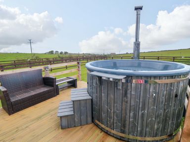 An outdoor seating area with a hot tub at Swift Cabin in Staintondale near Scarborough