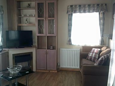 A living room with a television and sofa at Coopers Beach Holiday Park - Holiday Accommodation 3999 Mersea Island