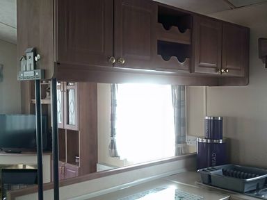 A kitchen with cabinets and a television at Coopers Beach Holiday Park - Holiday Accommodation 3999 Mersea Island