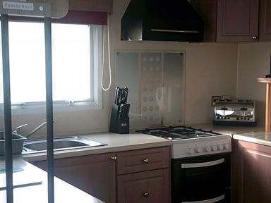 A kitchen with a cooking range, sink, and toaster at Coopers Beach Holiday Park - Holiday Accommodation 3999 Mersea Island
