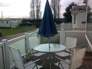 An outdoor patio with a table and chairs at Coopers Beach Holiday Park - Holiday Accommodation 3999 Mersea Island