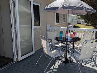 A deck with a table and chairs at Coopers Beach Holiday Park - Holiday Accommodation 6404 Mersea Island