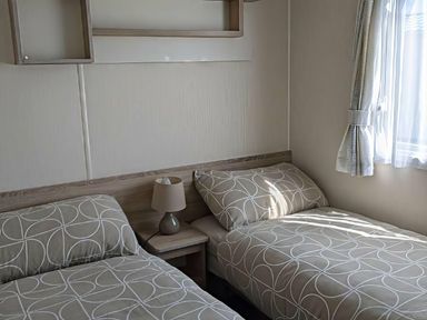 A bedroom with two beds and a side table at Coopers Beach Holiday Park - Holiday Accommodation 6404 Mersea Island