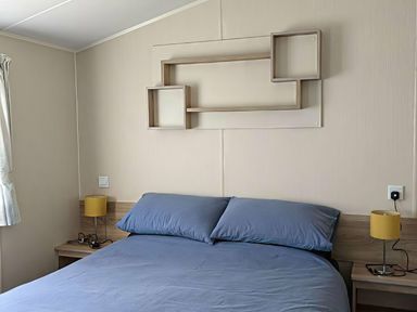 A bedroom with a bed and a shelf at Coopers Beach Holiday Park - Holiday Accommodation 6404, Mersea Island