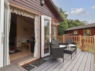 A patio area with chairs and a table at Kingfisher Lodge in Windermere