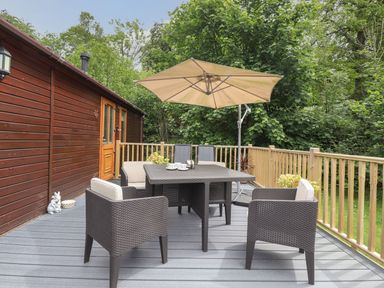 A outdoor seating area with a table and chairs at Kingfisher Lodge in Windermere