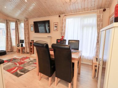 A dining room with a table and chairs at Kingfisher Lodge Grasmere 33, White Cross Bay near Windermere