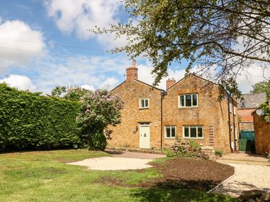 A house and garden with a pathway and trees at The Old Bakery in Banbury