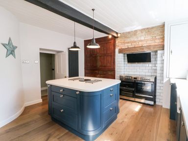A kitchen with an island and stove at The Old Bakery in Banbury