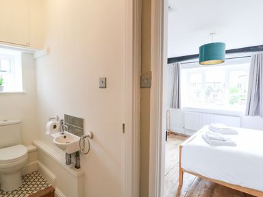 A bathroom and bedroom area with a bed and sink at The Old Bakery in Banbury