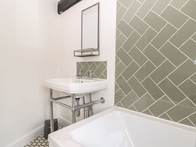 A bathroom featuring a basin and bathtub at The Old Bakery in Banbury