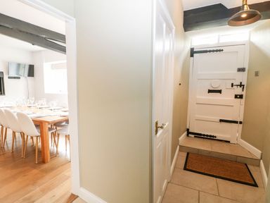 A hallway with a door and view of a dining area at The Old Bakery in Banbury