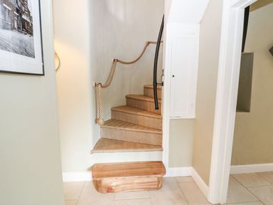 A staircase with a handrail and storage at The Old Bakery in Banbury