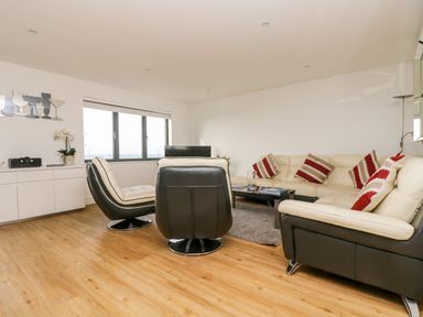 A living room with a sofa and armchair at Praa Waves in Penzance