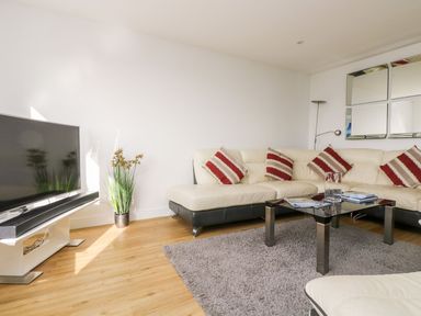 A living room with a sofa and television at Praa Waves in Penzance